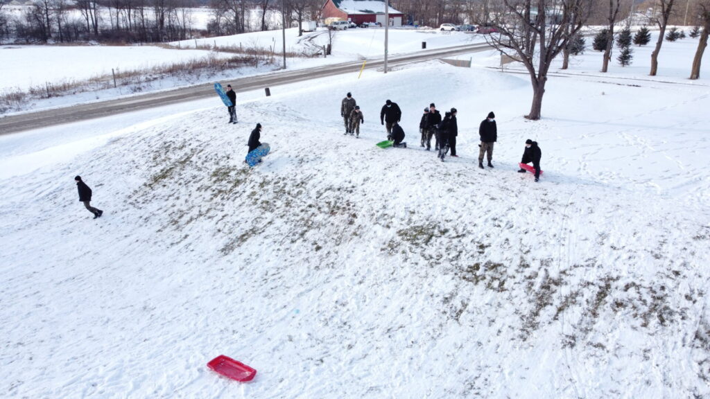Students sledding down a hill