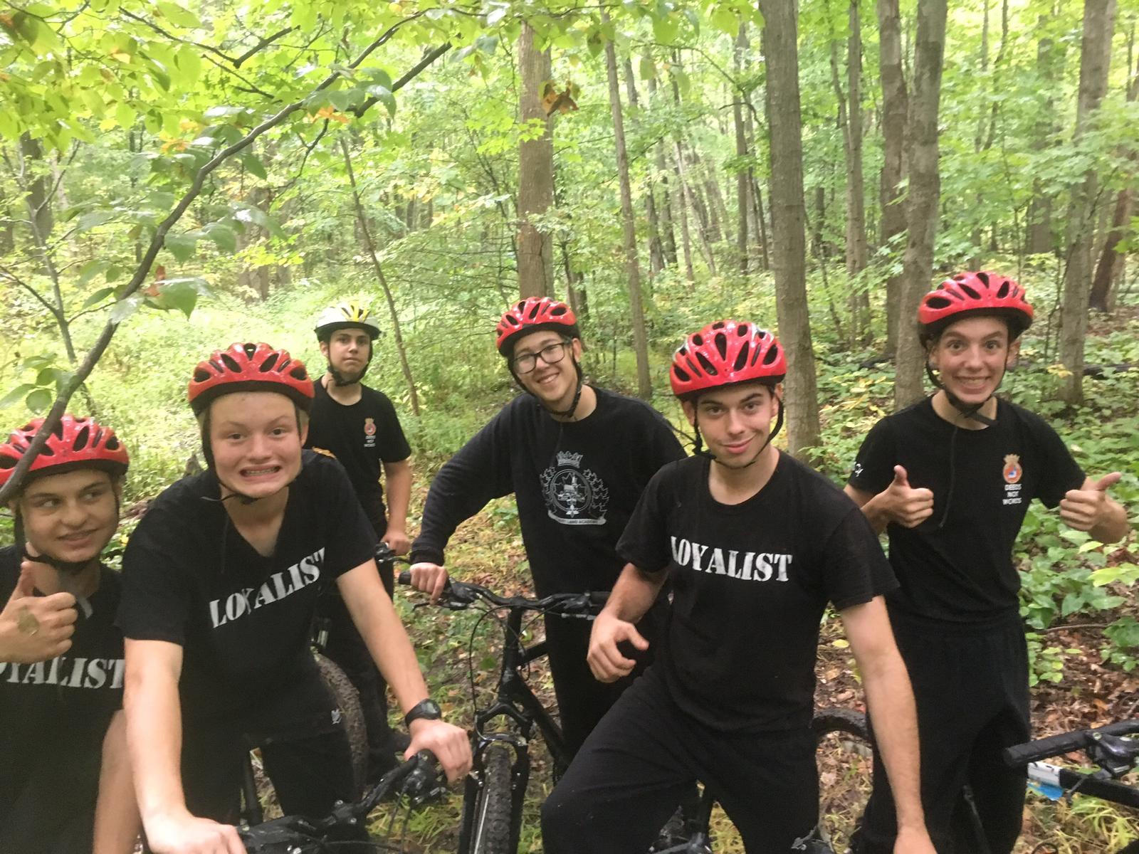 Students biking on a path in the woods